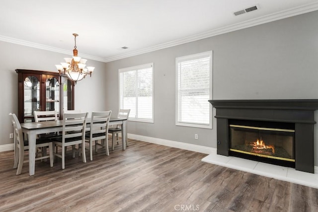 dining room featuring crown molding, hardwood / wood-style flooring, and a chandelier