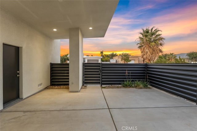 patio terrace at dusk featuring a balcony