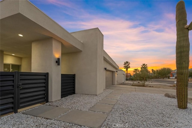 property exterior at dusk featuring a garage