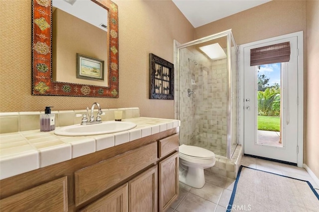 bathroom with vanity, tile patterned floors, a shower with door, and toilet