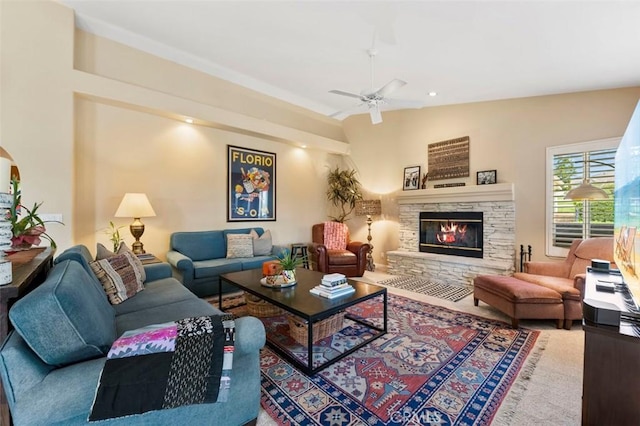 living room with ceiling fan, lofted ceiling, and a fireplace