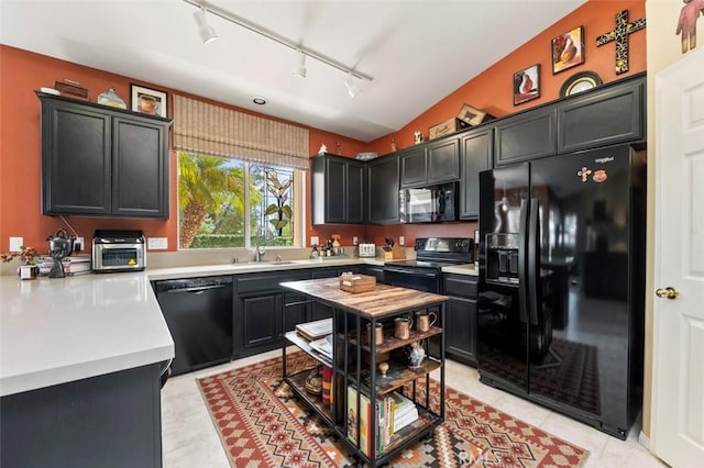 kitchen featuring lofted ceiling, sink, black appliances, and light tile patterned flooring