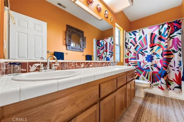 full bathroom with tile patterned flooring, vanity, shower / bath combo, and toilet