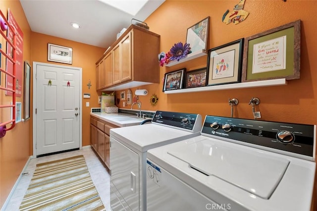 laundry room with cabinets, sink, and washing machine and dryer