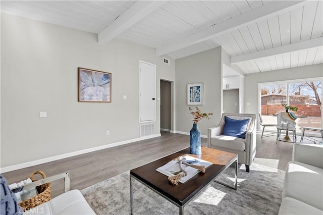 living room featuring wood-type flooring and vaulted ceiling with beams