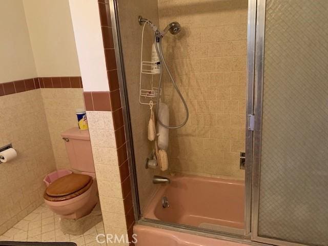 14650 Pearl Ave, Clearlake, CA 95422 - full bath with combined bath / shower with glass door, tile walls, and wainscoting