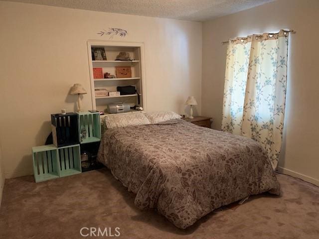 bedroom with a textured ceiling and carpet flooring