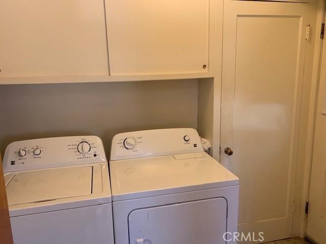 washroom with cabinets and washer and clothes dryer