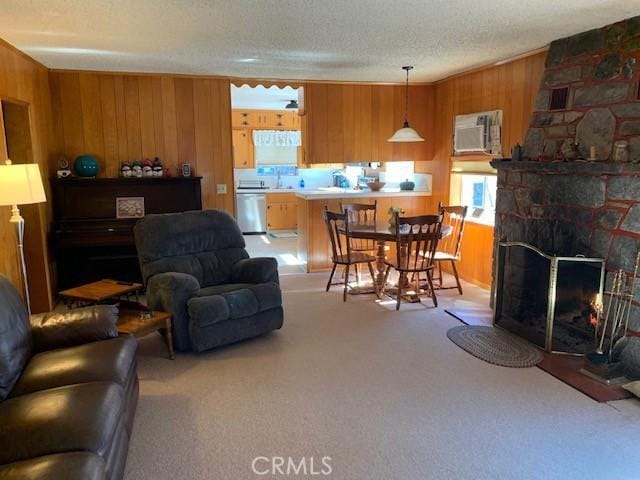 living room featuring a fireplace, a textured ceiling, light carpet, and wood walls