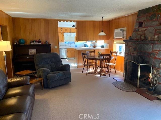14650 Pearl Ave, Clearlake, CA 95422 - carpeted living room featuring wooden walls, plenty of natural light, a stone fireplace, and a textured ceiling