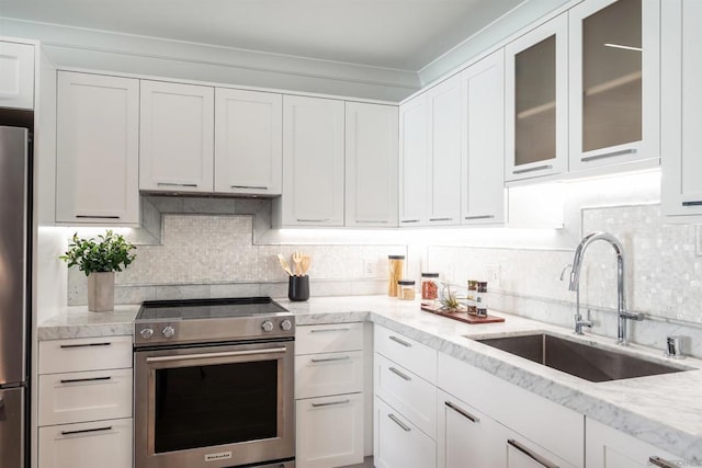 kitchen with white cabinetry, appliances with stainless steel finishes, sink, and backsplash