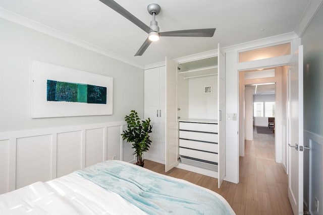 bedroom with crown molding, ceiling fan, and light wood-type flooring