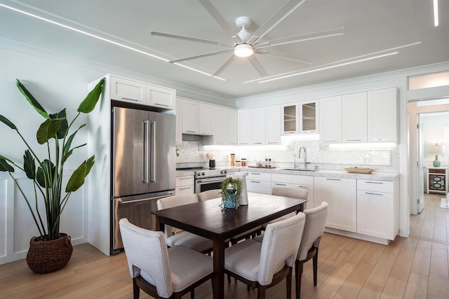 kitchen featuring high quality appliances, tasteful backsplash, sink, and white cabinets