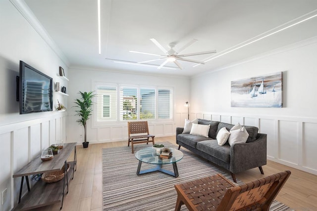 living room featuring ornamental molding, light hardwood / wood-style floors, and ceiling fan