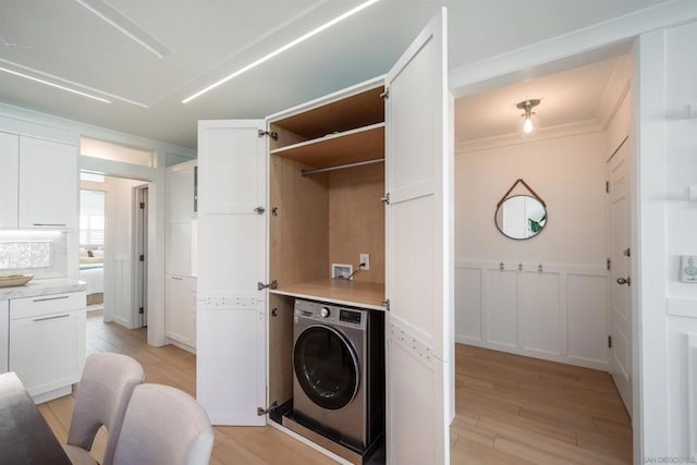 laundry area with washer / clothes dryer, crown molding, and light wood-type flooring