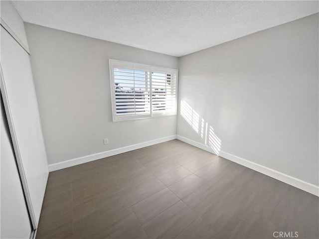 unfurnished room with a textured ceiling