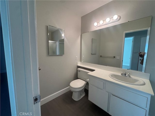 bathroom featuring vanity, hardwood / wood-style flooring, and toilet