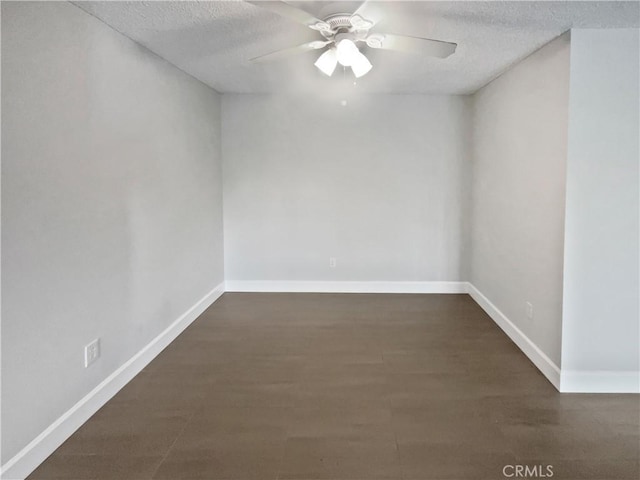 unfurnished room featuring ceiling fan, dark hardwood / wood-style flooring, and a textured ceiling