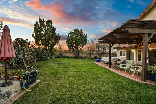 yard at dusk with a pergola and a patio area