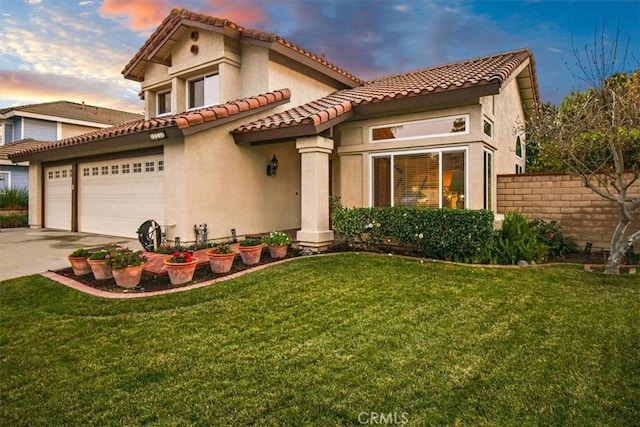 mediterranean / spanish home featuring a yard and a garage