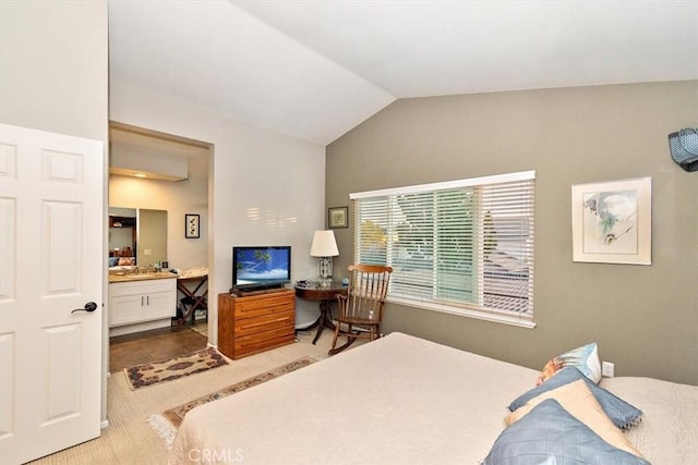 bedroom featuring carpet floors, ensuite bath, and vaulted ceiling