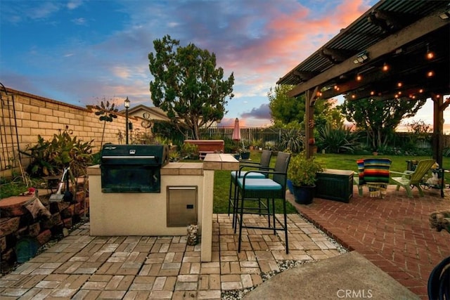 patio terrace at dusk with a pergola, area for grilling, grilling area, and a jacuzzi