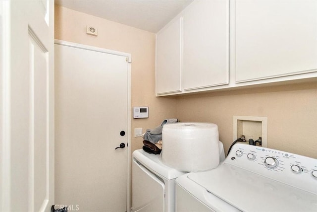 washroom featuring washer and clothes dryer and cabinets