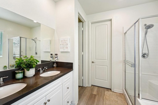 bathroom with vanity, a shower with shower door, and hardwood / wood-style floors