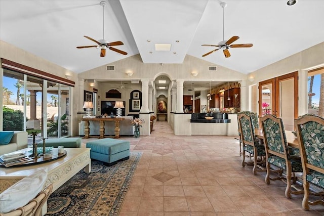 living room with ceiling fan, high vaulted ceiling, light tile patterned floors, and ornate columns