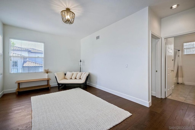 sitting room featuring a notable chandelier, a wealth of natural light, and dark hardwood / wood-style floors