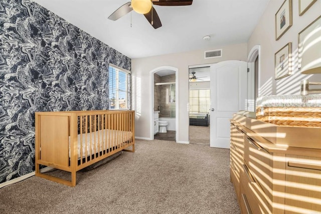 carpeted bedroom with ceiling fan and ensuite bath