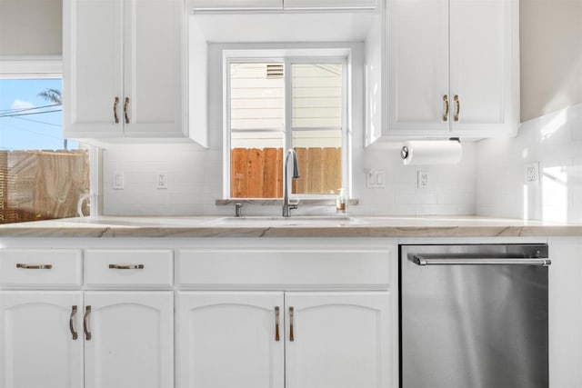 kitchen featuring white cabinetry, sink, stainless steel dishwasher, and decorative backsplash