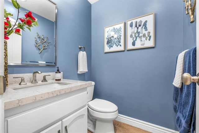 bathroom featuring hardwood / wood-style flooring, vanity, and toilet