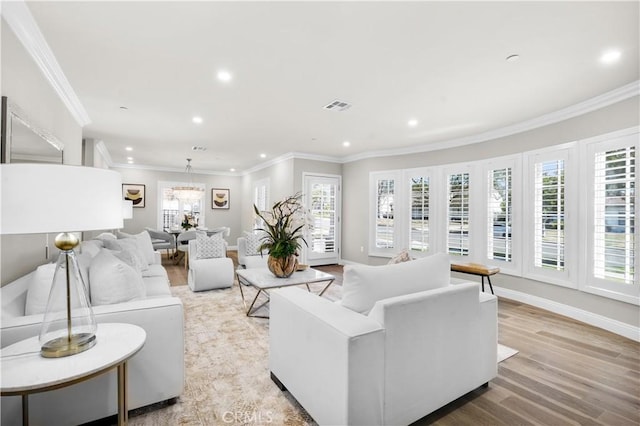 living room with crown molding and light hardwood / wood-style floors