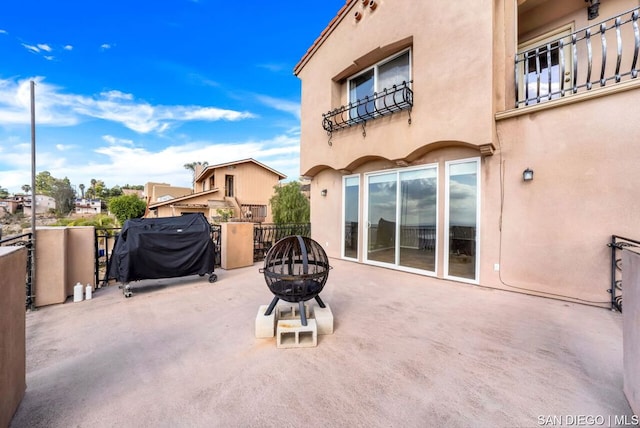 view of patio with a balcony, an outdoor fire pit, and a grill