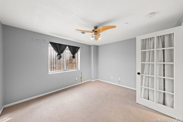 carpeted spare room with ceiling fan