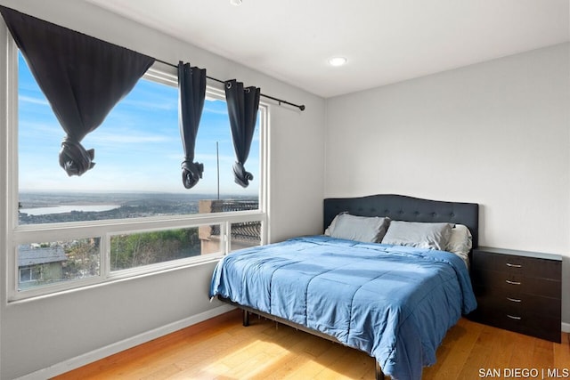 bedroom with a water view and light wood-type flooring