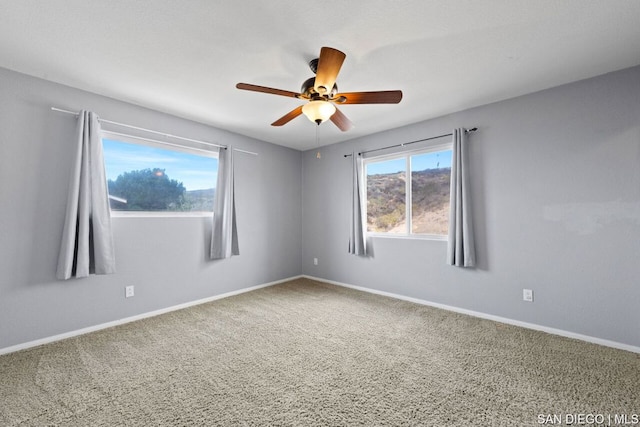 carpeted spare room featuring ceiling fan