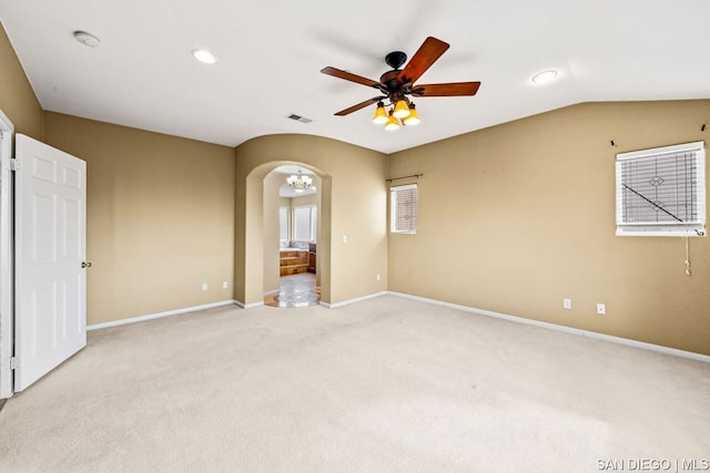 spare room featuring vaulted ceiling, light colored carpet, and ceiling fan