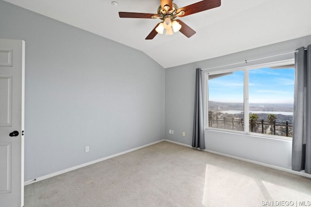 spare room with vaulted ceiling, light colored carpet, and ceiling fan