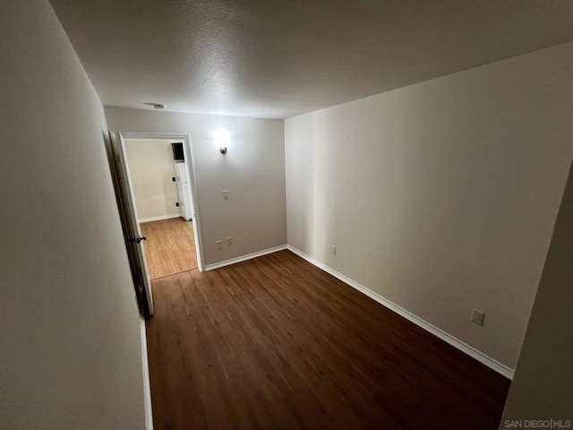 empty room with dark wood-type flooring