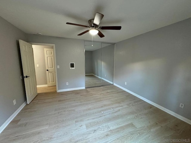 unfurnished bedroom with light hardwood / wood-style flooring, ceiling fan, and a closet