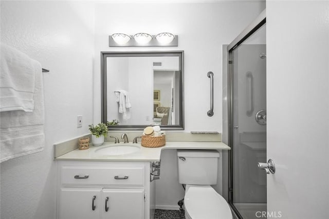 bathroom with vanity, toilet, and a shower with shower door