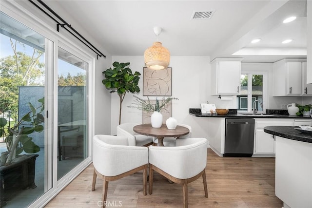 dining area with sink and light hardwood / wood-style flooring