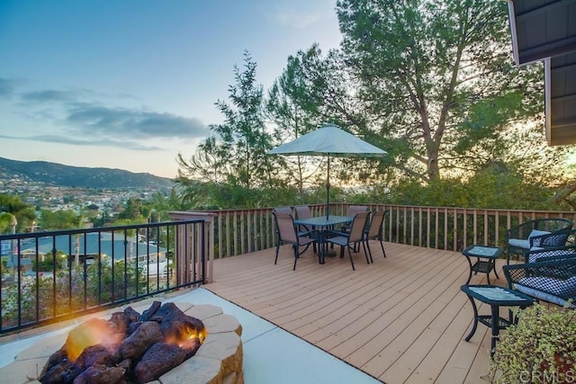 deck at dusk with a mountain view and a fire pit