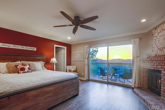 bedroom with crown molding, hardwood / wood-style flooring, ceiling fan, a fireplace, and access to outside