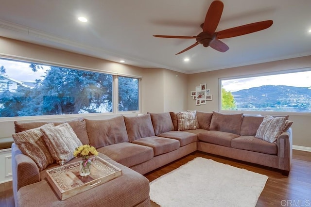 living room with a mountain view, ornamental molding, dark hardwood / wood-style floors, and ceiling fan