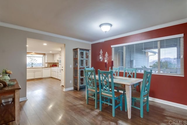 dining area with wood-type flooring, sink, and crown molding