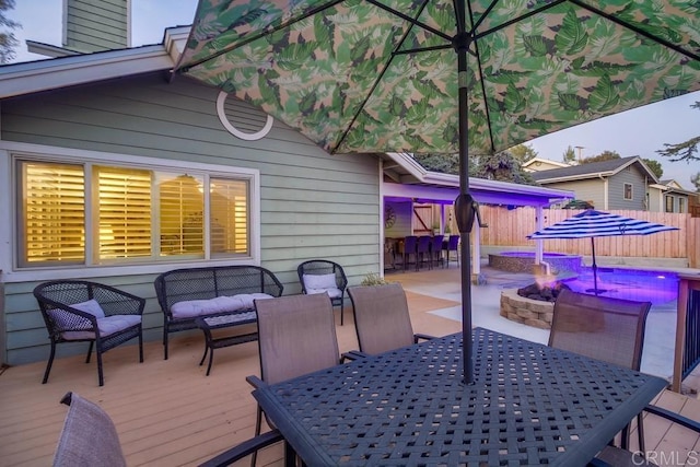 deck with an outdoor living space with a fire pit