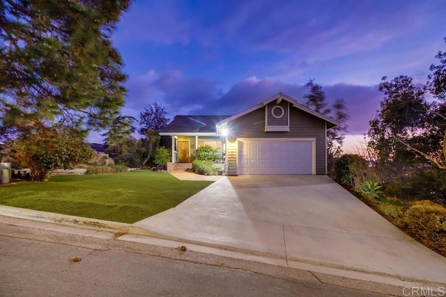 view of front of property with a garage and a lawn